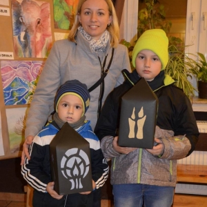 Zdjęcie przedstawia uczestników warsztatów rodzinnych z wykonanymi lampionami adwentowymi