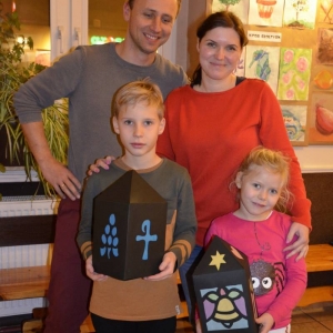 Zdjęcie przedstawia uczestników warsztatów rodzinnych z wykonanymi lampionami adwentowymi