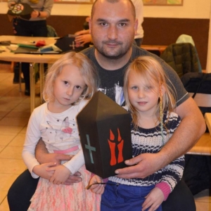 Zdjęcie przedstawia uczestników warsztatów rodzinnych z wykonanym lampionem adwentowym