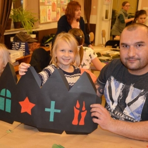 Zdjęcie przedstawia uczestników warsztatów rodzinnych z wykonanymi lampionami adwentowymi