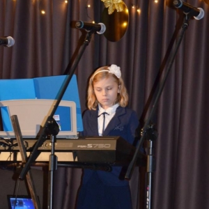 Zdjęcie przedstawia uczennicę zajęć keyboardowych podczas noworocznego koncertu kolędowego