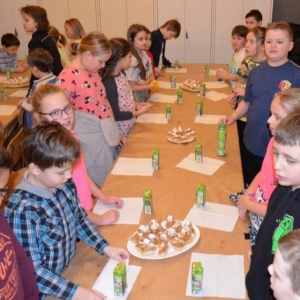 Zdjęcie przedstawia wspólny słodki poczęstunek uczestników zimowiska