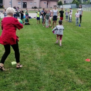 Zdjęcie przedstawia uczestników półkolonii podczas wspólnej zabawy na boisku sportowym