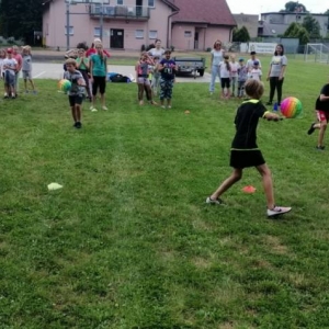 Zdjęcie przedstawia uczestników półkolonii podczas wspólnej zabawy na boisku sportowym