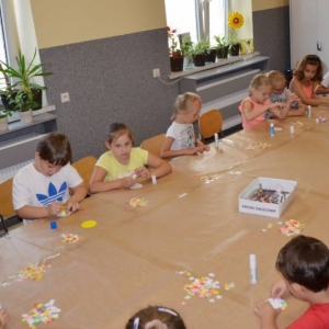 Zdjęcie przedstawia tworzenie prac plastycznych przez uczestników półkolonii