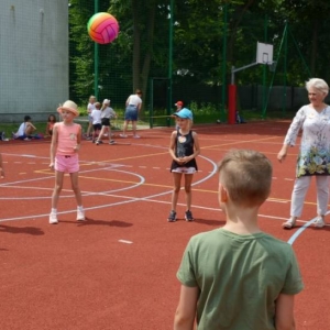 Zdjęcie przedstawia wspólną zabawę na boisku sportowym uczestników półkolonii