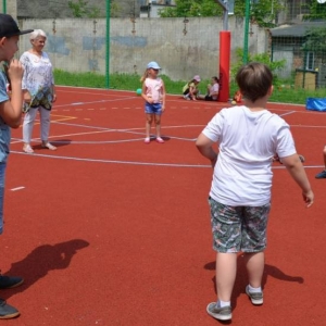 Zdjęcie przedstawia wspólną zabawę na boisku sportowym uczestników półkolonii