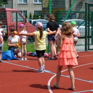 Zdjęcie przedstawia wspólną zabawę na boisku sportowym uczestników półkolonii