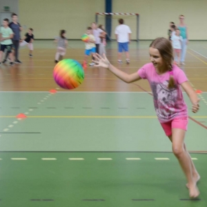 Zdjęcie przedstawia uczestników półkolonii na hali sportowej 