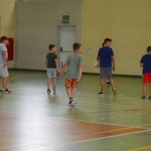 Zdjęcie przedstawia uczestników półkolonii na hali sportowej 