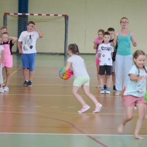 Zdjęcie przedstawia uczestników półkolonii na hali sportowej 