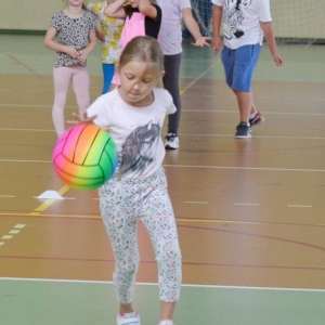 Zdjęcie przedstawia uczestników półkolonii na hali sportowej 