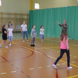 Zdjęcie przedstawia uczestników półkolonii na hali sportowej 