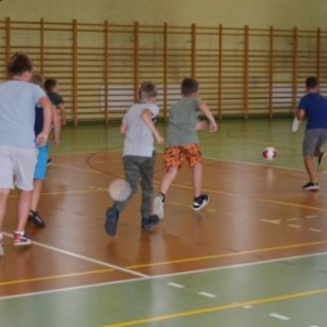 Zdjęcie przedstawia uczestników półkolonii na hali sportowej 