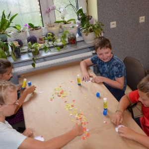 Zdjęcie przedstawia tworzenie prac plastycznych przez uczestników półkolonii