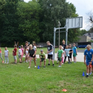 Zdjęcie przedstawia uczestników wypoczynku w czasie zabawy na boisku sportowym w Nakle Śląskim