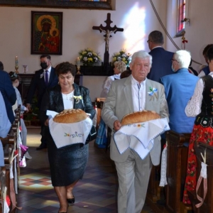 Zdjęcie przedstawia Starostów dożynkowych niosących chleby dożynkowe