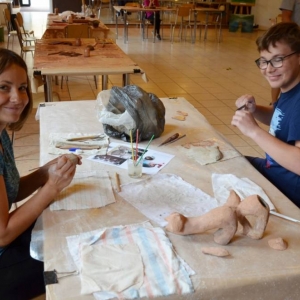 Zdjęcie przedstawia uczestników warsztatów ceramicznych podczas wykonywania swoich prac