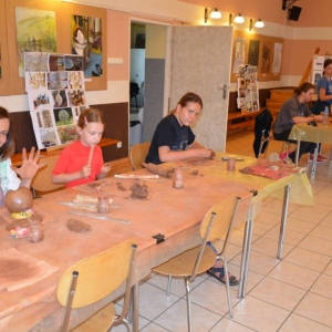 Zdjęcie przedstawia uczestników warsztatów ceramicznych podczas wykonywania swoich prac