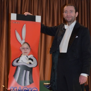Zdjęcie przedstawia uczestników półkolonii podczas występu iluzjonisty