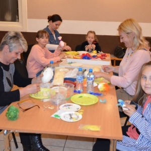 Zdjęcie przedstawia uczestników warsztatów podczas tworzenia swoich pisanek