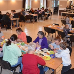 Zdjęcie przedstawia uczestników warsztatów podczas tworzenia swoich pisanek