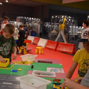 Zdjęcie przedstawia uczestników półkolonii II turnusu w trakcie wycieczki na wystawę klocków LEGO podczas zwiedzania i wspólnej zabawy.