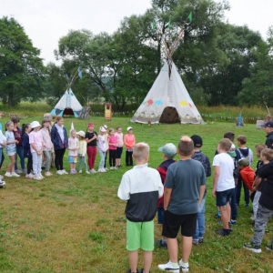Drugiego dnia uczestnicy półkolonii odwiedzili wioskę indiańską w Karchowicach. Zdjęcie przedstawia dzieci podczas wspólnej zabawy w wiosce indiańskiej.