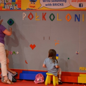 Zdjęcie przedstawia uczestników półkolonii II turnusu w trakcie wycieczki na wystawę klocków LEGO podczas zwiedzania i wspólnej zabawy.