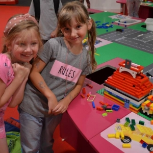 Zdjęcie przedstawia uczestników półkolonii II turnusu w trakcie wycieczki na wystawę klocków LEGO podczas zwiedzania i wspólnej zabawy.