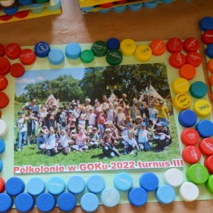 Zdjęcie przedstawia pracę plastyczną - ramkę na zdjęcie grupowe, wykonaną podczas pierwszego dnia III turnusu półkolonii.