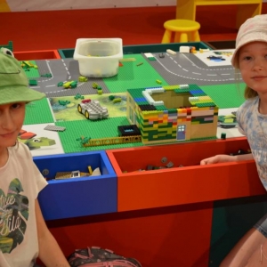 Zdjęcie przedstawia uczestników półkolonii IV turnusu w trakcie wycieczki na wystawę klocków LEGO podczas zwiedzania i wspólnej zabawy. 