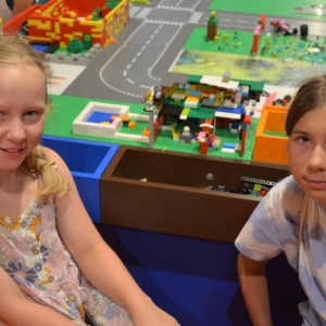 Zdjęcie przedstawia uczestników półkolonii IV turnusu w trakcie wycieczki na wystawę klocków LEGO podczas zwiedzania i wspólnej zabawy. 