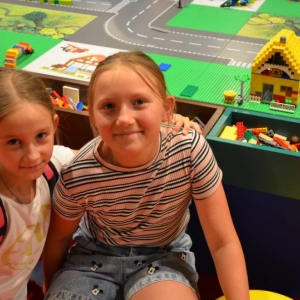 Zdjęcie przedstawia uczestników półkolonii IV turnusu w trakcie wycieczki na wystawę klocków LEGO podczas zwiedzania i wspólnej zabawy. 