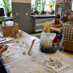 Zdjęcie przedstawia uczestników warsztatów ceramicznych podczas wykonywania swoich prac