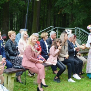 Częstowanie chlebem dożynkowym publiczność znajdującą się przed sceną
