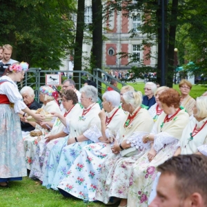Częstowanie chlebem dożynkowym publiczność znajdującą się przed sceną