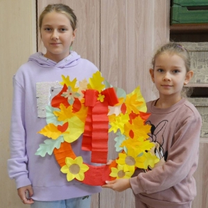 Uczestniczki zajęć z wykonanymi jesiennymi pracami plastycznymi