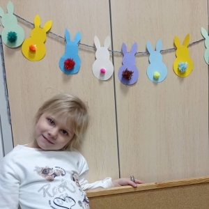 Zdjęcie przedstawia uczestniczkę zajęć plastycznych oraz przygotowane ozdoby świąteczne