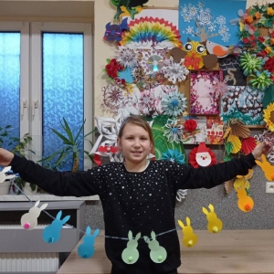 Zdjęcie przedstawia uczestniczkę zajęć plastycznych oraz przygotowane ozdoby świąteczne