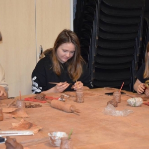 Zdjęcie przedstawia uczestników warsztatów podczas wykonywania swoich prac ceramicznej