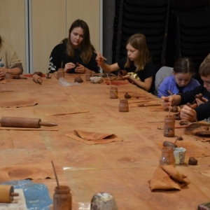 Zdjęcie przedstawia uczestników warsztatów podczas wykonywania swoich prac ceramicznej