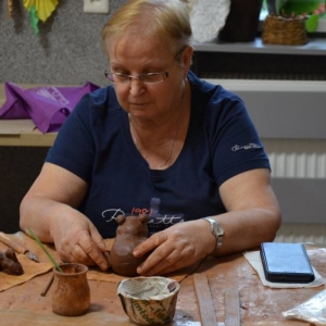Zdjęcie przedstawia uczestnika warsztatów podczas wykonywania swojej pracy ceramicznej