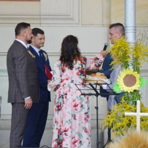 Zdjęcie przedtsawia Starostów dożynkowych przekazujących chleby dożynkowe Włodarzom Gminy