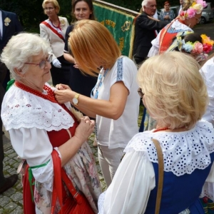 Zdjęcie przedstawia przypinanie kotylionów dożynkowych zaproszonym gościom