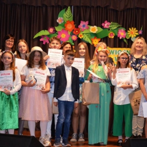 Zdjęcie grupowe grupy uczestników konkursu wokalnego w grupie starszej wraz z Jury oraz dyrektor GOK Świerklaniec.