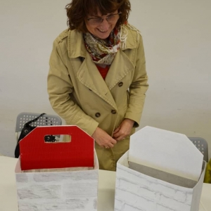 Zdjęcie przedstawia uczestniczkę rodzinnych warsztatów z wykonanymi tego dnia pracami