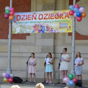 Zdjęcie przedstawia uczestników Dnia Dziecka występujących na scenie amfiteatru w świerklanieckim parku