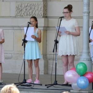 Zdjęcie przedstawia uczestników Dnia Dziecka występujących na scenie amfiteatru w świerklanieckim parku