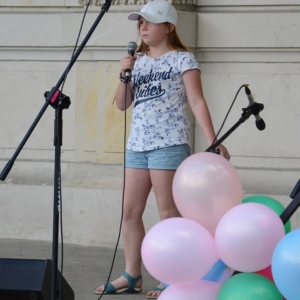 Zdjęcie przedstawia uczestniczkę Dnia Dziecka występującą na scenie amfiteatru w świerklanieckim parku